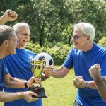 Team of mature football players winning the cup